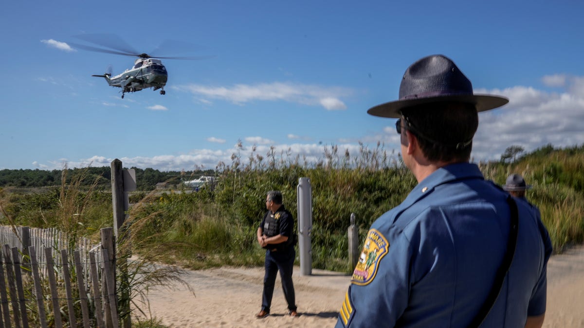 A Delaware State Trooper watches as Marine One carrying U.S. President Joe Biden takes off from Gordons Pond in Rehoboth Beach, Delaware, U.S., September 20, 2021. REUTERS/Ken Cedeno