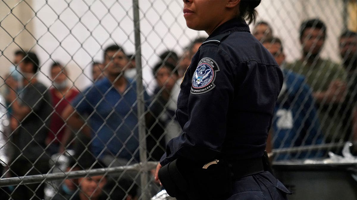 U.S. Customs and Border Protection agent monitors detainees at Border Patrol station in McAllen, Texas, on July 12, 2019.