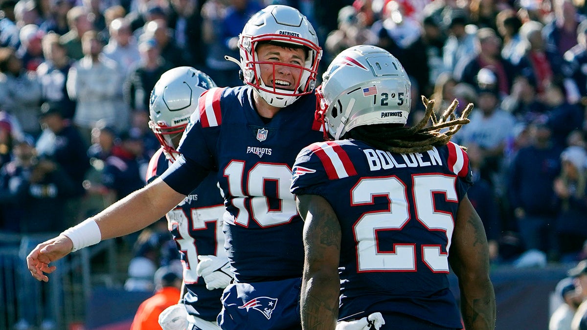 New England Patriots running back Brandon Bolden (25) celebrates with quarterback Mac Jones (10) after his touchdown during the first half of an NFL football game against the New York Jets, Sunday, Oct. 24, 2021, in Foxborough, Massachusetts.