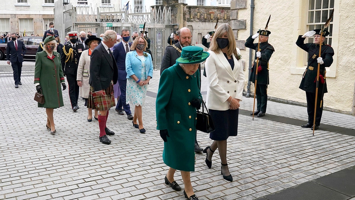 Britain's Queen Elizabeth II, center, arrives at the Scottish Parliament in Edinburgh, followed by Prince Charles and Camilla, Duchess of Cornwall, left, where she will deliver a speech in the debating chamber to mark the official start of the sixth session of Parliament, in Edingurgh, Scotland.