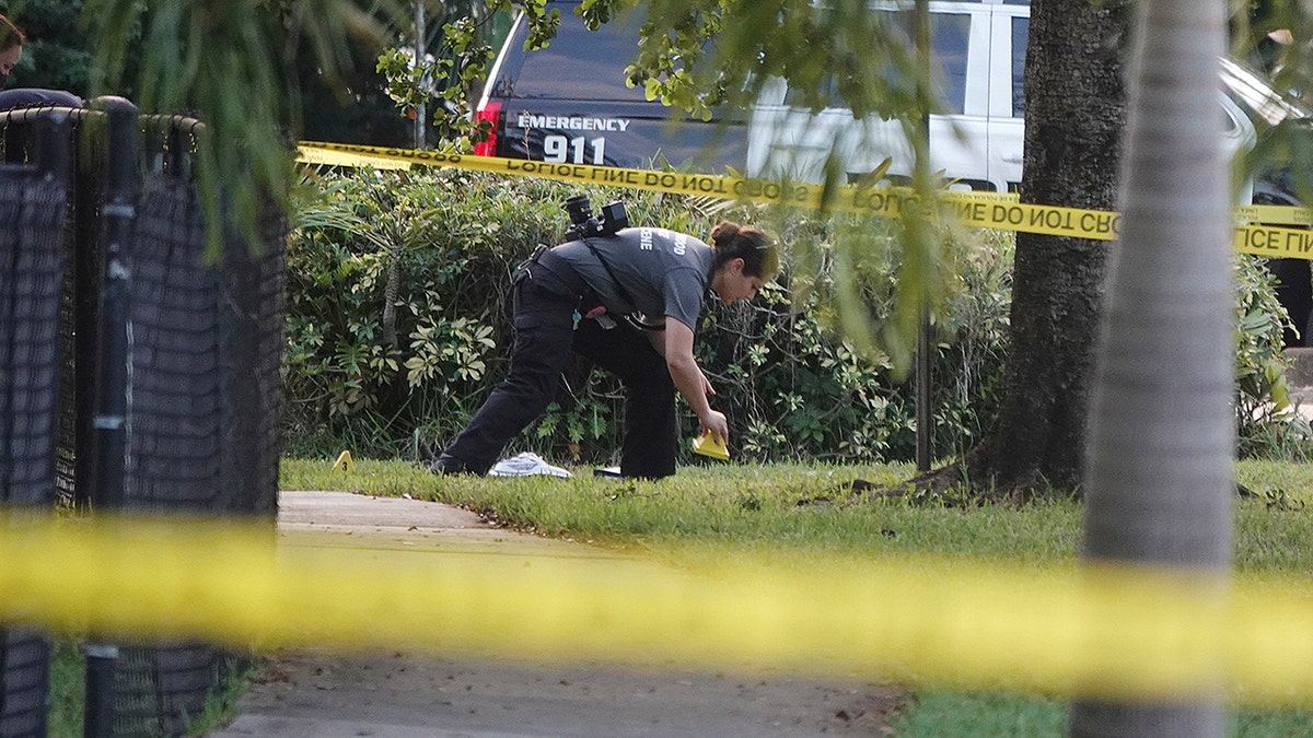 A Hollywood Police crime scene investigator places markers at the scene where officer Yandy Chirino was killed in Hollywood, Fla.