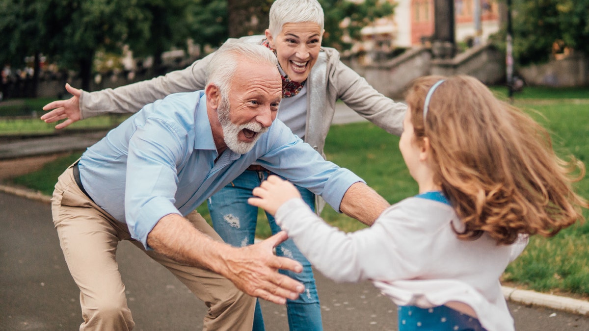 Granddaughter running towards her grandparents