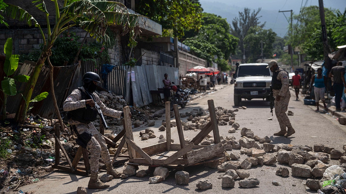 Police remove a roadblock set by protesters in Port-au-Prince, Haiti, on Monday.