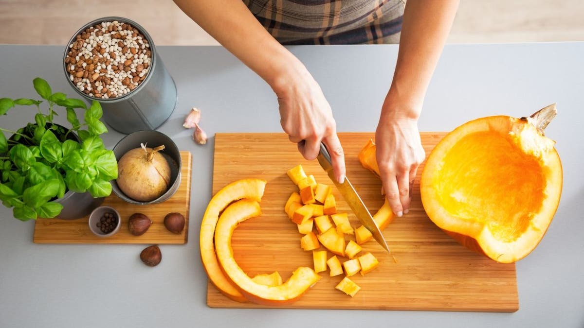 Person cuts up a pumpkin