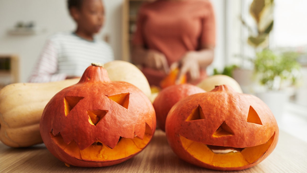 child and adult with jack-o-lanterns