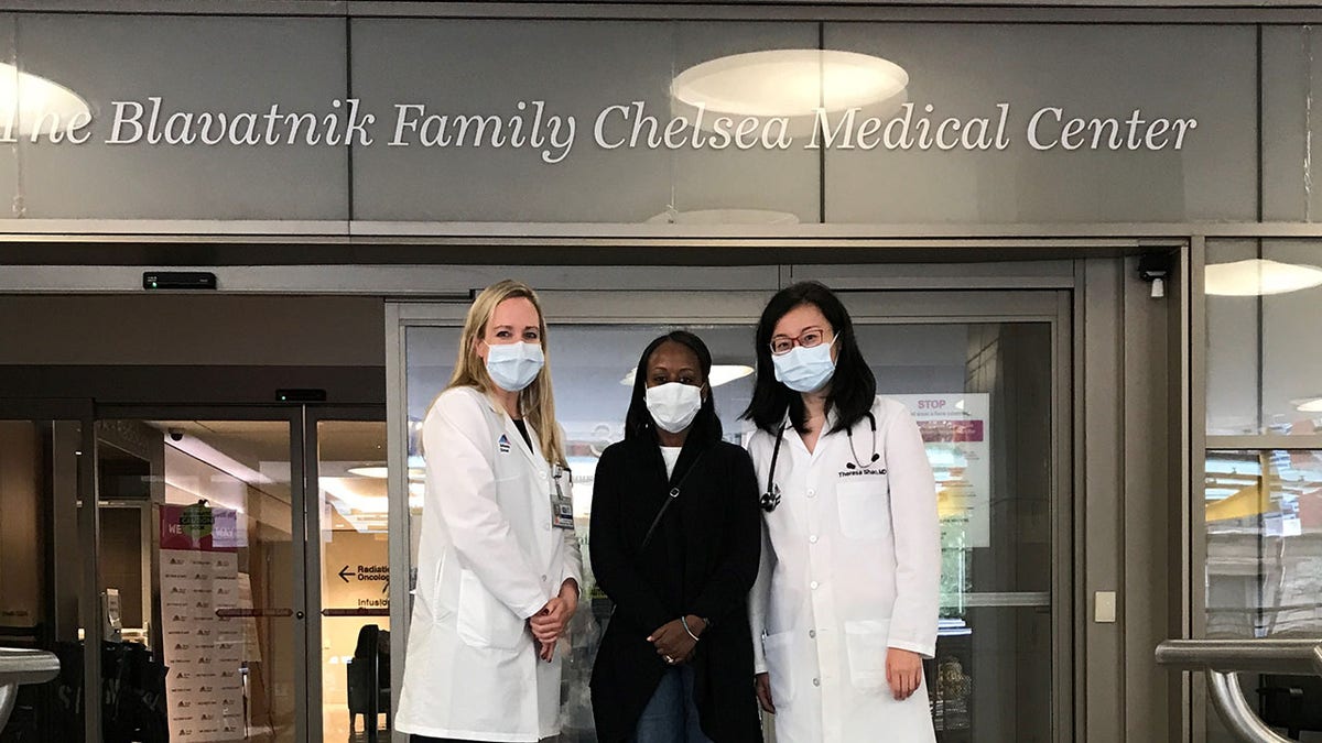 From left, Dr. Sarah Cate, director of the special surveillance and breast program at Mount Sinai Beth Israel; patient Woobie Rust and Dr. Theresa Shao, hematology and oncology specialist, stand in front of the Chelsea Medical Center at Mount Sinai where Rust receives her cancer care.