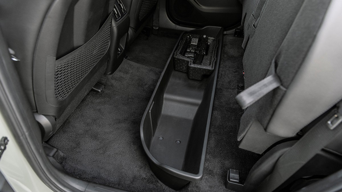 A storage compartment is hidden under the rear seats.