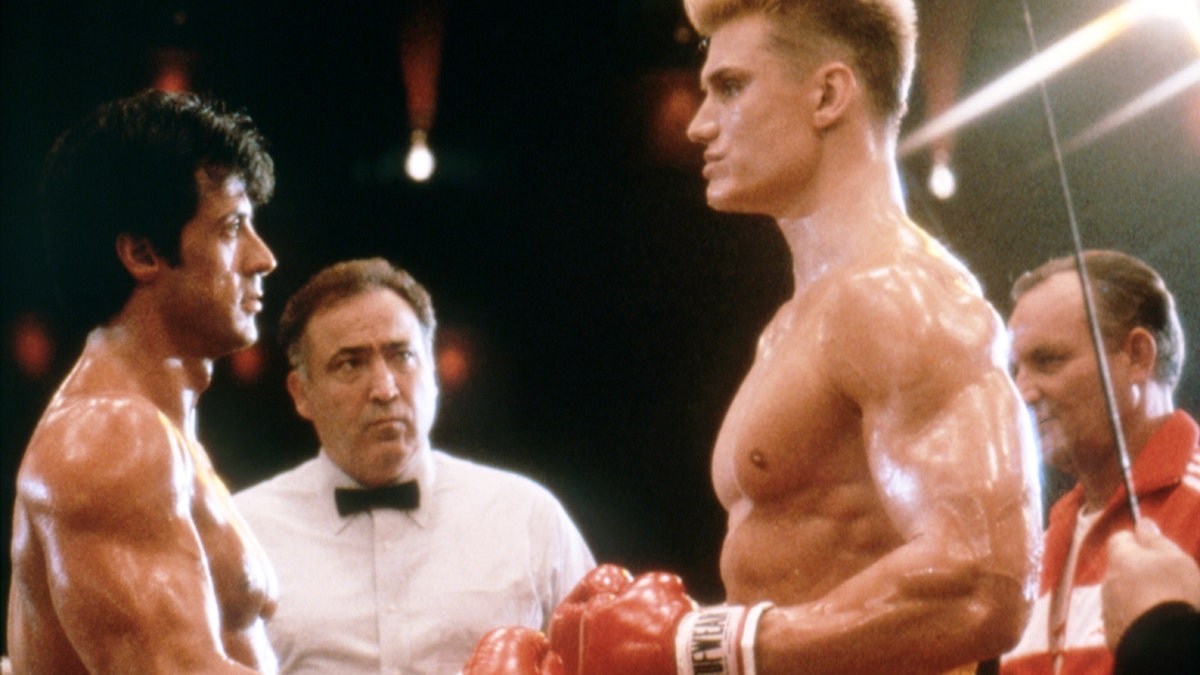 Sylvester Stallone and Dolph Lundgren hit boxing gloves in Rocky IV