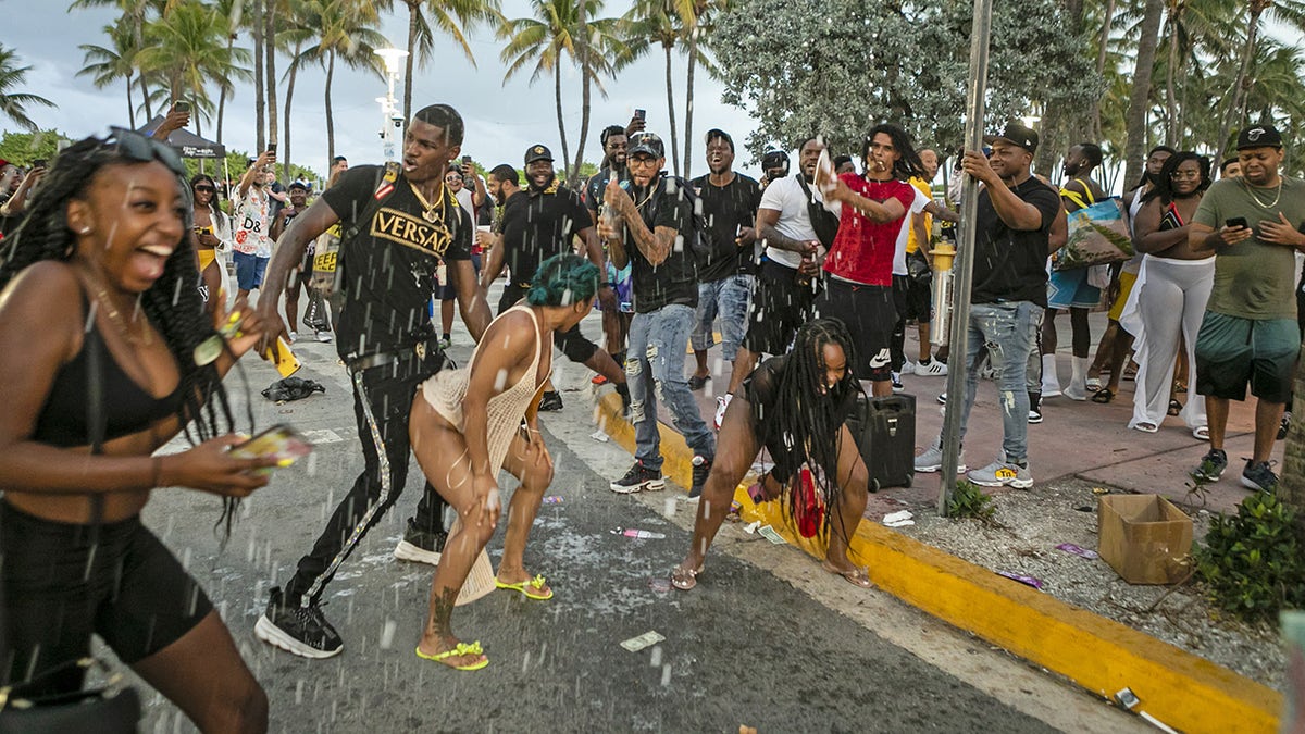 People party along Ocean Drive in the South Beach neighborhood of Miami, Florida, on Saturday, March 27, 2021. 