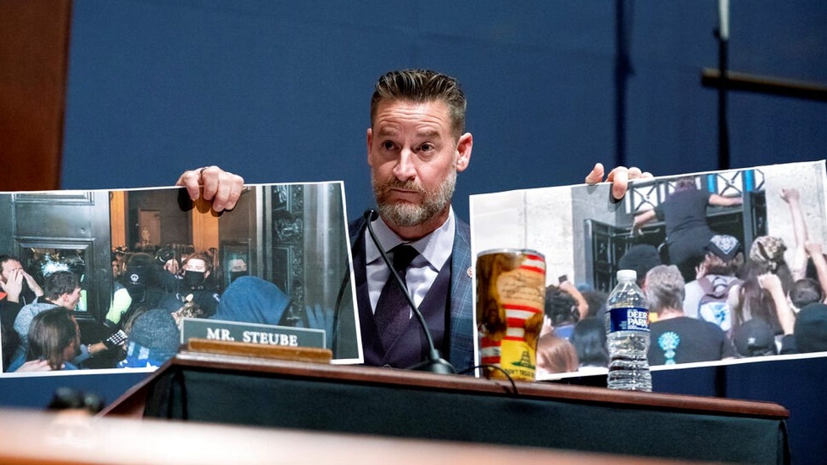 Rep. Greg Steube, R-Fla., holds photo from the Jan. 6, attack on the Capitol as he questions Attorney General Merrick Garland during a House Judiciary Committee oversight hearing of the Department of Justice on Thursday, Oct. 21, 2021, on Capitol Hill in Washington. (Greg Nash/Pool via AP)