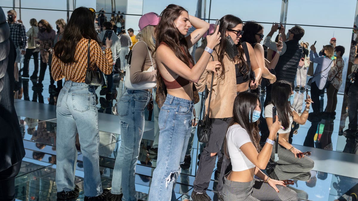 Young women take photos in the mirrors while visiting Summit One Vanderbilt as it opens to the general public Oct. 21, 2021 in New York City. Summit One Vanderbilt is an immersive experience and observation deck featuring the permanent "Air" installation by Kenzo Digital. It also includes an outdoor terrace, a glass elevator on the exterior of the building, and glass bottom booths overlooking Madison Avenue. 