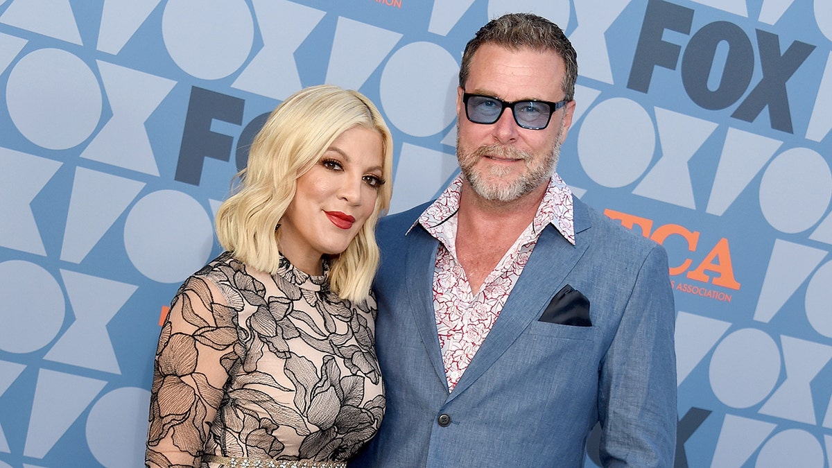 Tori Spelling posing with husband Dean McDermott at an event
