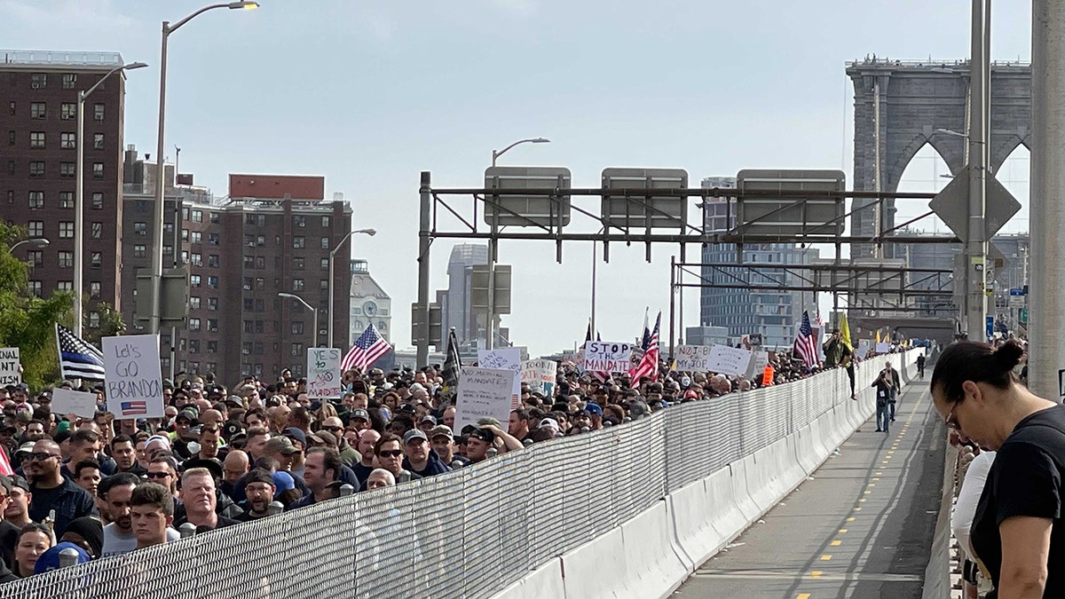 Hundreds of New York City employees and their supporters march over the Brooklyn Bridge roadway on Monday.