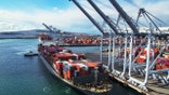 Drone shot of a massive container ship arriving in the Port of Long Beach, California.