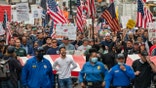 People march across the Brooklyn Bridge to protest the Covid-19 vaccine mandate for municipal workers on October 25, 2021 in New York City. All city workers, excluding uniformed correction officers, are required to have at least one dose of the COVID-19 vaccine by 5pm on October 29th.