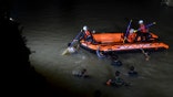Rescuers search for victims of drowning in a river in Ciamis, West Java, Indonesia, Friday, Oct. 15, 2021. A number of students drowned during a school outing for a river cleanup on Friday evening in Indonesia's West Java Province. (AP Photo/Yopi Andrias)