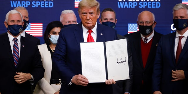 U.S. President Donald Trump signs an executive order on vaccine distribution during an Operation Warp Speed Vaccine Summit at the White House in Washington, U.S., December 8, 2020. REUTERS/Tom Brenner