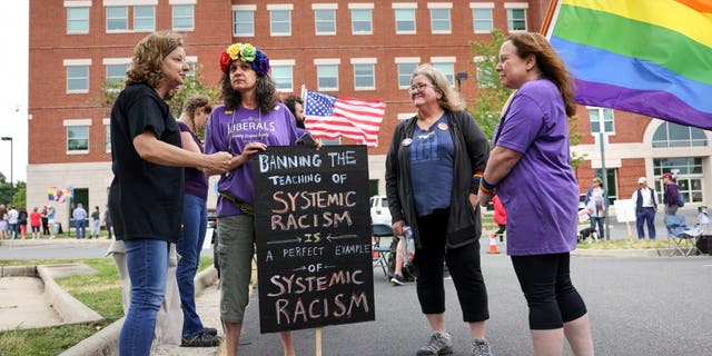 Supporters of the academic doctrine known as Critical Race Theory and transgender students meet outside the Loudoun County School Board headquarters before a school board meeting, in Ashburn, Virginia, U.S. June 22, 2021. REUTERS/Evelyn Hockstein