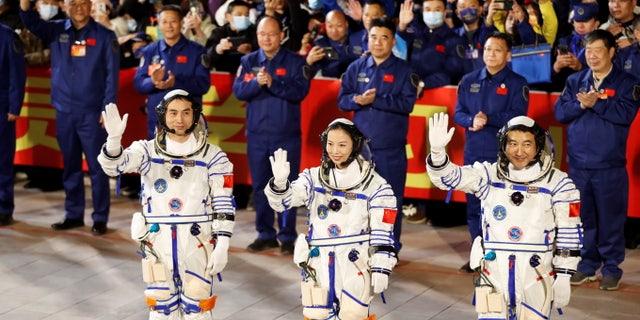 Astronauts Ye Guangfu, Zhai Zhigang and Wang Yaping wave during a ceremony ahead of the launch of the Long March-2F Y13 rocket, carrying the Shenzhou-13 spacecraft and them in China's second crewed mission to build its own space station, at Jiuquan Satellite Launch Center near Jiuquan, Gansu province, China,  October 15, 2021. REUTERS/Carlos Garcia Rawlins