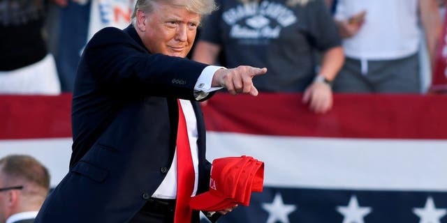 FILE FOTO: Ex Stati Uniti. President Donald Trump holds hats as he gestures during his first post-presidency campaign rally at the Lorain County Fairgrounds in Wellington, Ohio, NOI., giugno 26, 2021. REUTERS/Gaelen Morse/File Photo