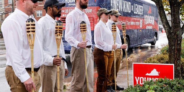 A small group of demonstrators dressed in "Unite the right" Gathering enthusiasts with tiki torches stand on a sidewalk as Virginia Republican gubernatorial candidate Glenn Youngkin arrives on his bus for a campaign event at a Mexican restaurant in Charlottesville, Virginia, USA on 29 October 2021. REUTERS / Jonathan Ernst