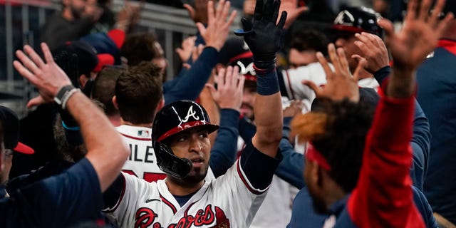 Atlanta Braves' Eddie Rosario, center, celebrates after hitting a three run home run during the fourth inning in Game 6 of baseball's National League Championship Series against the Los Angeles Dodgers Saturday, Oct. 23, 2021, in Atlanta.