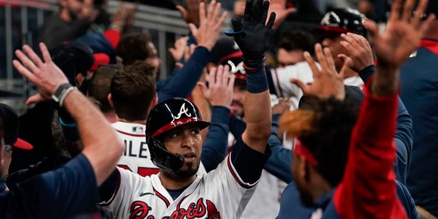 Atlanta Braves' Eddie Rosario, sentrum, celebrates after hitting a three run home run during the fourth inning in Game 6 of baseball's National League Championship Series against the Los Angeles Dodgers Saturday, Okt.. 23, 2021, in Atlanta.