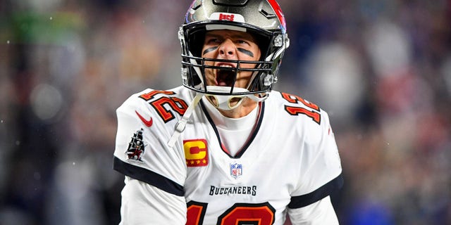 Tampa Bay Buccaneers quarterback Tom Brady yells to the crowd as he takes the field to face the New England Patriots at Gillette Stadium.  