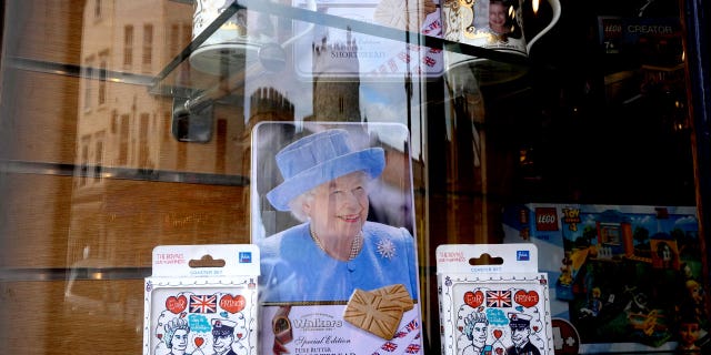 Windsor Castle is reflected in the window of a shop selling royal souvenirs outside the castle in Windsor, England, Friday, Oct. 22, 2021. (AP Photo/Kirsty Wigglesworth)