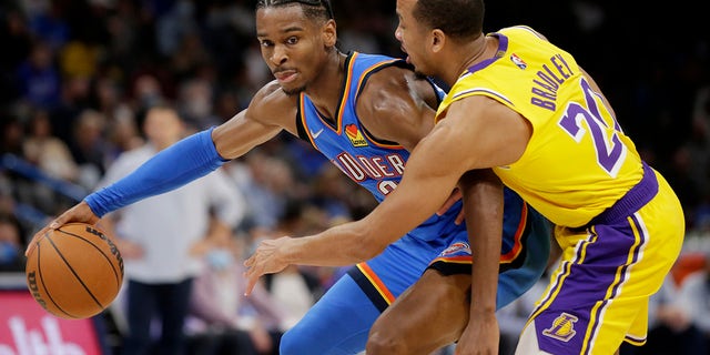 Oklahoma City Thunder guard Shai Gilgeous-Alexander (2) goes against Los Angeles Lakers guard Avery Bradley (20) during the second half of an NBA basketball game, Wednesday, Oct. 27, 2021, in Oklahoma City.