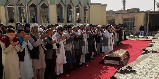 Relatives and residents pray during a funeral ceremony for victims of a suicide attack at the Gozar-e-Sayed Abad Mosque in Kunduz, northern Afghanistan, on Saturday, October 9, 2021. The mosque was filled with Shiite Muslim worshipers when an Islamic State suicide bomber attacked during Friday prayers and killed dozens in the latest security challenge to the Taliban as they transitioned from insurgency to government.  (AP Photo / Abdullah Sahil)