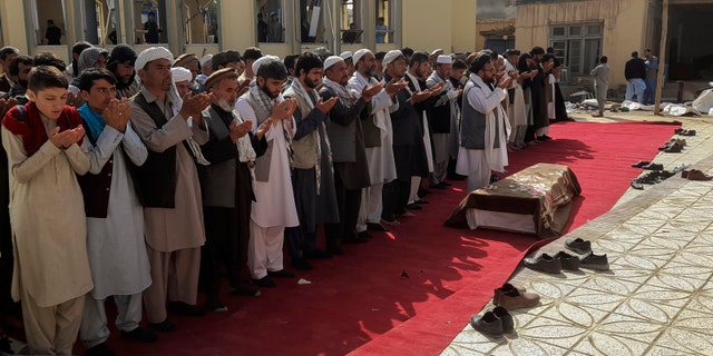 Relatives and residents pray during a funeral ceremony for victims of a suicide attack at the Gozar-e-Sayed Abad Mosque in Kunduz, northern Afghanistan, Saturday, Oct. 9, 2021. The mosque was packed with Shiite Muslim worshippers when an Islamic State suicide bomber attacked during Friday prayers, killing dozens in the latest security challenge to the Taliban as they transition from insurgency to governance. (AP Photo/Abdullah Sahil)