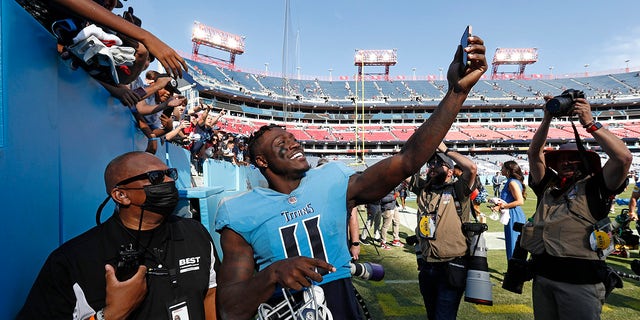 Tennessee Titans wide receiver A.J. Brown (11) takes a picture for a fan as he leaves the field after the Titans beat the Kansas City Chiefs 27-3 in an NFL football game Sunday, Oct. 24, 2021, in Nashville, Tenn.