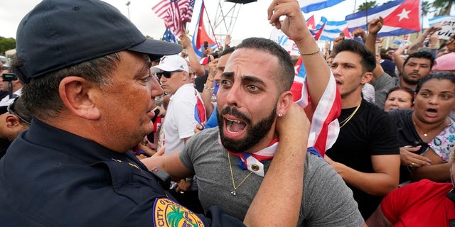 In this Wednesday, July 14, 2021, file photo, Miami Police Chief Art Acevedo, left, hugs a demonstrator, in Miami's Little Havana neighborhood, as people rallied in support of antigovernment demonstrations in Cuba. City of Miami commissioners held a special meeting last month in which they attacked Acevedo less than six months into his post, and voted to further investigate him and his appointment. (AP Photo/Wilfredo Lee, File)