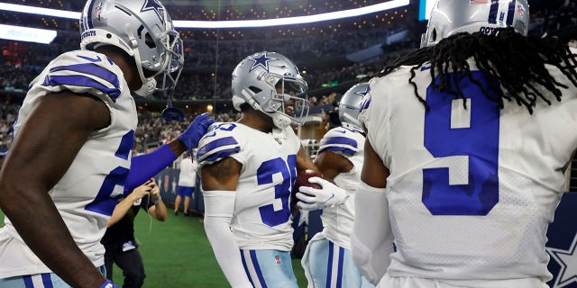Dallas Cowboys cornerback Anthony Brown (30), Jaylon Smith (9) and others celebrate an interception by Brown in the first half of an NFL football game against the Philadelphia Eagles in Arlington, Texas, Monday, Sept. 27, 2021. (AP Photo/Michael Ainsworth)
