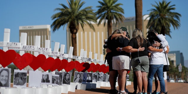 In this Oct. 1, 2019, file photo, people pray at a makeshift memorial for shooting victims in Las Vegas, on the anniversary of the mass shooting two years earlier. People who died, will be remembered Friday, Oct. 1, 2021, during the fourth anniversary of the Las Vegas massacre that became the deadliest mass shooting in modern U.S. history.