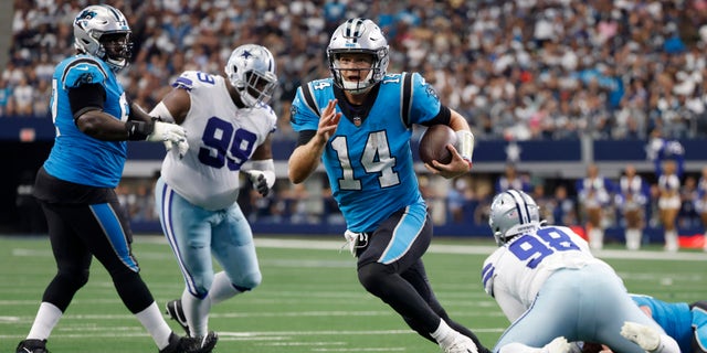 Carolina Panthers quarterback Sam Darnold (14) runs the ball past Dallas Cowboys defensive tackle Justin Hamilton (99) and Quinton Bohanna (98) to the end zone for a touchdown in the first half of an NFL football game in Arlington, Texas, Sunday, Oct. 3, 2021.