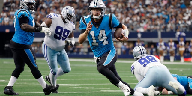 Carolina Panthers quarterback Sam Darnold (14) runs the ball past Dallas Cowboys defensive tackle Justin Hamilton (99) and Quinton Bohanna (98) to the end zone for a touchdown in the first half of an NFL football game in Arlington, Texas, Sunday, Oct. 3, 2021.