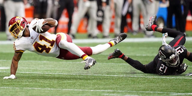 Washington Football Team running back J.D. McKissic (41) falls after a hit by Atlanta Falcons strong safety Duron Harmon (21) during the second half of game Sunday, Oct. 3, 2021, in Atlanta.