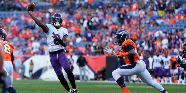 Baltimore Ravens quarterback Lamar Jackson (8) throws as Denver Broncos linebacker AJ Johnson continues during the second half of an NFL football game on Sunday, Oct. 3, 2021, in Denver.