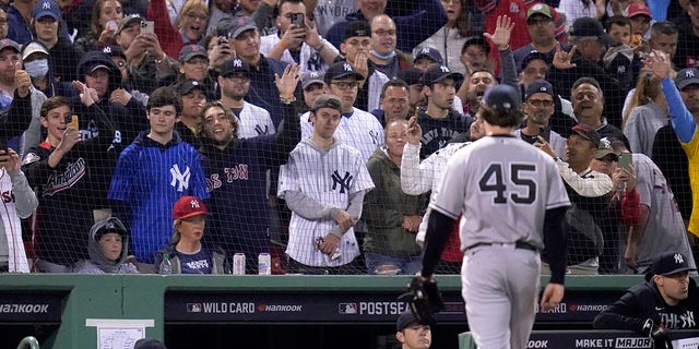 Fans react as New York Yankees starting pitcher Gerrit Cole (45) is eliminated in the third inning of an American League playoff baseball game against the Boston Red Sox at Fenway Park on Tuesday October 5, 2021, in Boston.  (AP Photo / Charles Krupa)