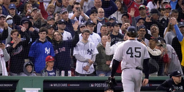 Los fanáticos reaccionan cuando el lanzador abridor de los Yankees de Nueva York, Gerrit Cole (45), es expulsado en la tercera entrada del juego de béisbol Wild Card de la Liga Americana contra los Medias Rojas de Boston en Fenway Park, el martes 2 de octubre de 2019. 5, 2021, en Boston.
