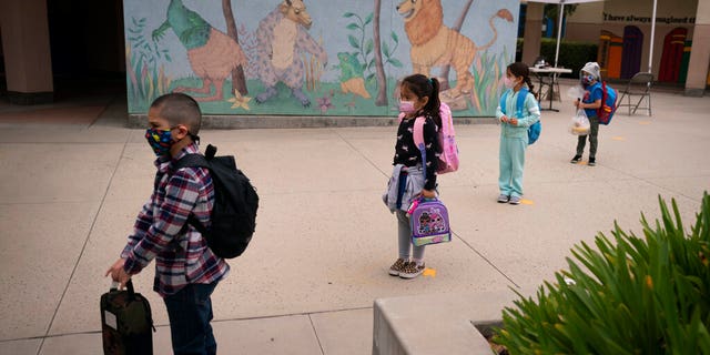 FILE — In this April 13, 2021, file photo socially distanced kindergarten students wait for their parents to pick them up on the first day of in-person learning at Maurice Sendak Elementary School in Los Angeles, Tuesday, April 13, 2021. (AP Photo/Jae C. Hong, File)
