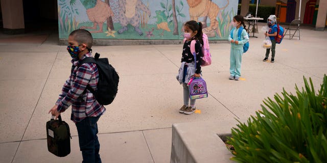 Socially distanced kindergarten students wait for their parents to pick them up on the first day of in-person learning (AP Photo/Jae C. Hong, File)