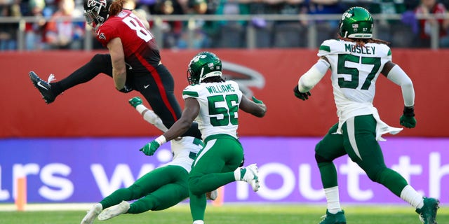Atlanta Falcons tight end Hayden Hurst (81) leaps over a tackle during the second half of an NFL football game between the New York Jets and the Atlanta Falcons at the Tottenham Hotspur stadium in London, England, Sunday, Oct. 10, 2021.