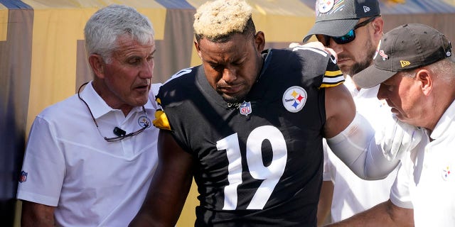 Pittsburgh Steelers wide receiver JuJu Smith-Schuster (19) is helped off the field after being injured during the first half against the Denver Broncos in Pittsburgh Oct. 10, 2021.