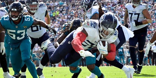Tennessee Titans running back Derrick Henry (22) dives for a touchdown past Jacksonville Jaguars linebacker Dakota Allen (53) during the second half of an NFL football game, Sunday, Oct. 10, 2021, in Jacksonville, Fla. (AP Photo/Phelan M. Ebenhack)