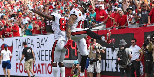 Tampa Bay Buccaneers wide receiver Mike Evans (13) celebrates his score against the Miami Dolphins with wide receiver Antonio Brown (81) during the second half of an NFL football game Sunday, Okt.. 10, 2021, in Tampa, Fla.