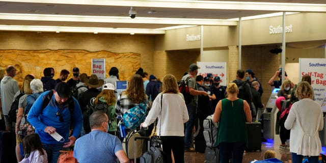 Passengers queue up at the ticketing counter for Southwest Airlines flights in Eppley Airfield, Sunday, Oct. 10, 2021, in Omaha, Neb.