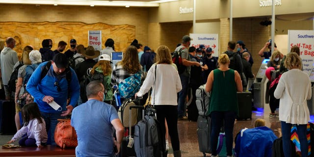 Passengers queue up at the ticketing counter for Southwest Airlines flights in Eppley Airfield, Sunday, Oct. 10, 2021, in Omaha, Neb.